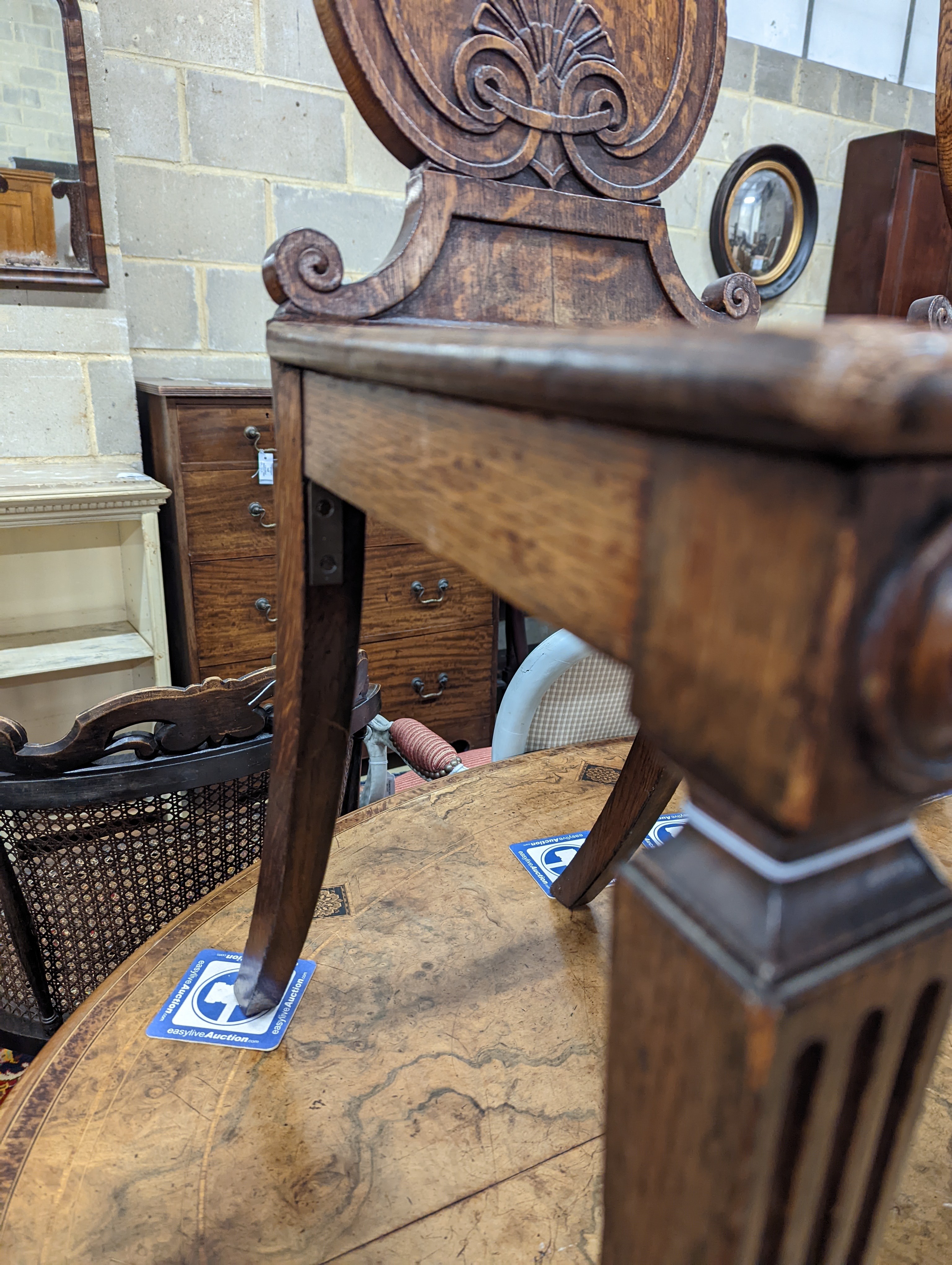 A pair of Victorian oak hall chairs with painted armorials, width 43cm, depth 39cm, height 94cm